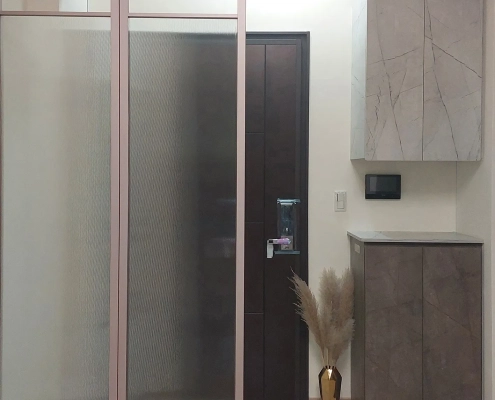全屋訂製玄關空間，結合可摺疊收起的金屬框玻璃屏風與下方專屬除濕防潮鞋櫃，兼具空間彈性界定與高效防潮功能｜霉不在家